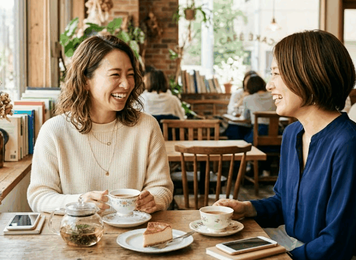 綺麗なカフェで友人とお茶をしている笑顔の女性